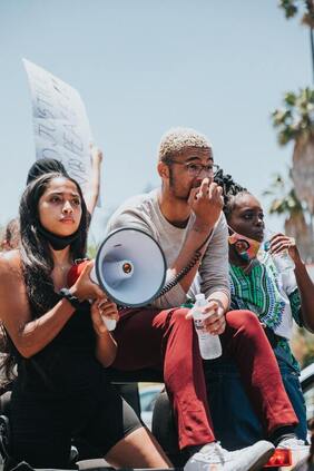 Young people with bullhorn and sign